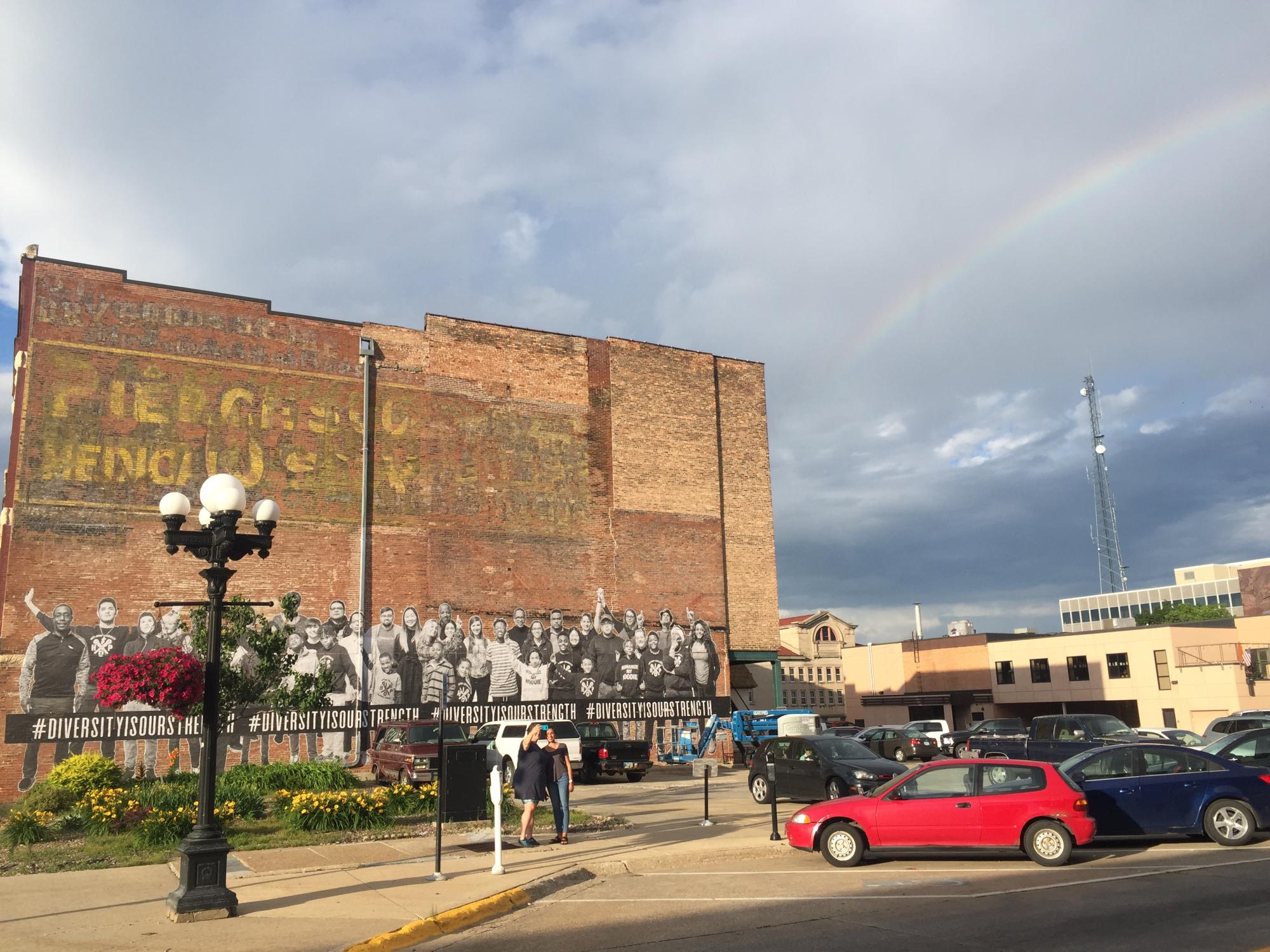 Rainbow over wheat paste mural